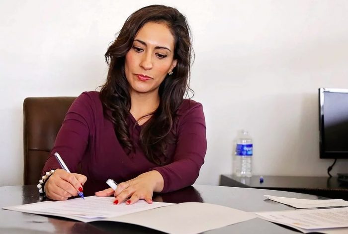 Mujer firmando una carta de renuncia de trabajo